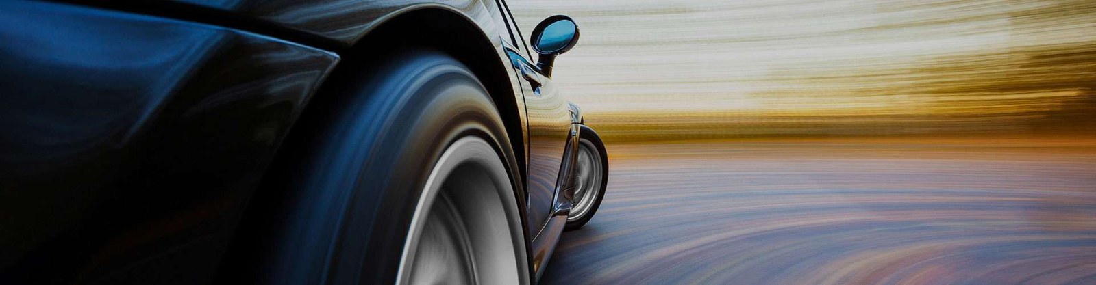 Fahrendes Fahrzeug auf Landstraße, Nahaufnahme des Vorderrads.